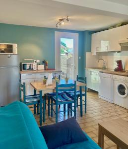 a kitchen and dining room with a table and chairs at Maisonnette 6 personnes à 500 m de la plage Parking 6GOEL18 in Le Barcarès