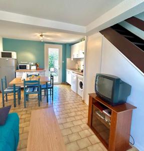 a living room with a tv and a dining room at Maisonnette 6 personnes à 500 m de la plage Parking 6GOEL18 in Le Barcarès