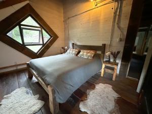 - une chambre avec un lit, une fenêtre et des tapis dans l'établissement Refugio Cerrito en Malalcahuello, à Malalcahuello
