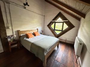 - une chambre avec un lit dans une pièce dotée d'une fenêtre dans l'établissement Refugio Cerrito en Malalcahuello, à Malalcahuello