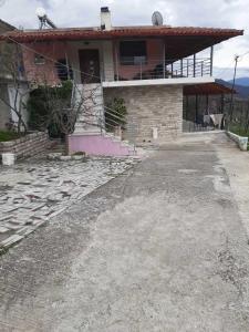 uma casa com uma entrada em frente em Garufalia em Peshkëpia e Poshtme