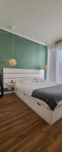 een slaapkamer met een wit bed en een blauwe muur bij cagnes promenade in Cagnes-sur-Mer