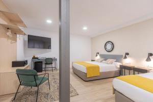 Habitación de hotel con cama, escritorio y mesa. en Soho Boutique Los Naranjos, en Málaga