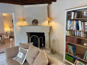 a living room with a couch and a fireplace at Maison Hermitage Campagne Chic - Vexin in Aincourt
