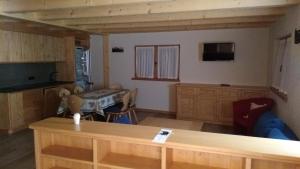 Una sala de estar con una mesa y una cocina. en Casa De Sandre, en San Vito di Cadore