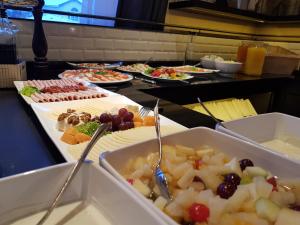 ein Buffet mit vielen verschiedenen Speisen in Tabletts in der Unterkunft Hotel Stümpelstal in Marburg an der Lahn