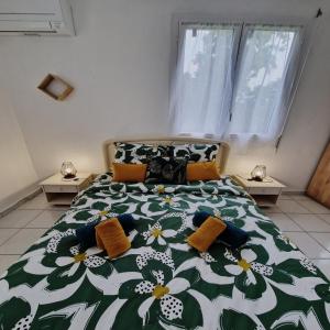 a bedroom with a green and white bed with pillows at Kaz'Bongo - Maison pour 6 en pleine nature in Capesterre-Belle-Eau