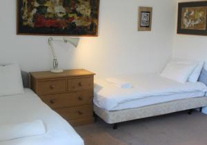 a bedroom with two beds and a lamp on a dresser at Cosy Family Cottage, Semi Rural Retreat - Dogs Welcome! Nearby Countryside, Beaches & Goodwood in Eartham