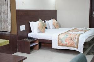 伯杰默里Hotel Indraprastha pachmarhi的有两张床和一张桌子的酒店房间