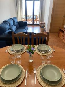 una mesa de madera con platos y copas de vino. en Mirador del Tiétar, en Mijares