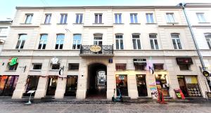 a large white building with a clock on it at Hostel Chmielna 5 Rooms & Apartments in Warsaw