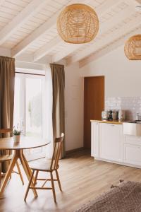 a kitchen and dining room with a table and chairs at Pure Flor de Esteva in Vila do Bispo
