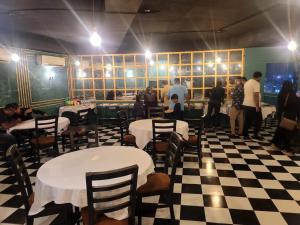 um restaurante com mesas e cadeiras e pessoas numa sala em Akbar’s Hotel em Dhaka