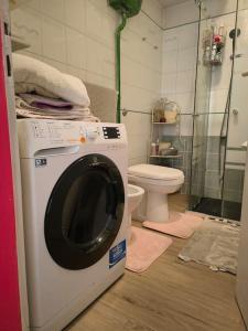 a washing machine in a bathroom with a toilet at Dependance in private garden ID29923 in Rome