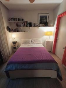 a bedroom with a large bed with a purple blanket at Dependance in private garden ID29923 in Rome