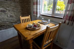 a wooden table with a plate of food on it at Winsford Cottage Wheddon Cross in Minehead