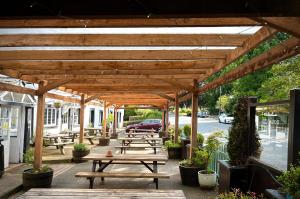 a group of picnic tables under a wooden pergola at Royal Oak Appleby in Appleby