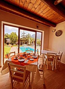een eetkamer met een tafel en stoelen en een zwembad bij Case vacanze le Buganville in Ischia