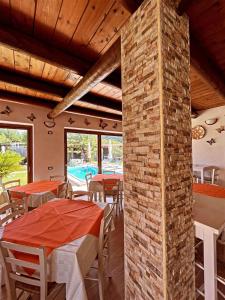 een eetkamer met tafels en stoelen en een bakstenen pilaar bij Case vacanze le Buganville in Ischia