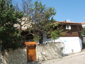 a house with a stone wall and a fence at Regina's Guesthouse in Balchik