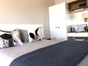 a bedroom with a large bed with two pillows at Small Bay Beach Suites in Cape Town