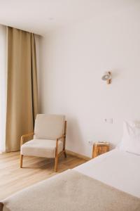 a bedroom with a bed and a chair at Pure Flor de Esteva in Vila do Bispo