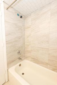 y baño con bañera y ducha. en 2-Bed Stylish Space mins to NYC, en Jersey City