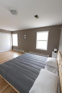 duże łóżko w sypialni z dwoma oknami w obiekcie 2-Bed Stylish Space mins to NYC w mieście Jersey City