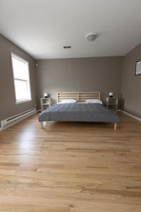 sypialnia z łóżkiem i drewnianą podłogą w obiekcie 2-Bed Stylish Space mins to NYC w mieście Jersey City