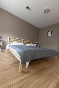 duże łóżko w sypialni z drewnianą podłogą w obiekcie 2-Bed Stylish Space mins to NYC w mieście Jersey City