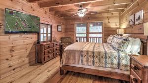 a bedroom with a bed and a flat screen tv at A Family Affair in Blue Ridge