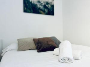 a white bed with towels on top of it at Hoxton Studios by DC London Rooms in London