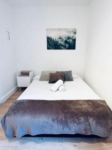 een slaapkamer met een groot bed en een deken bij Hoxton Studios by DC London Rooms in Londen