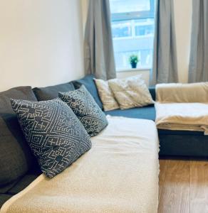 a blue couch with pillows on it in a living room at Hoxton Studios by DC London Rooms in London