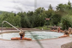 a group of people in a swimming pool at Natur'Eau Chalets & Spa in Mandeville