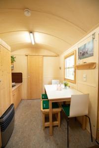 een kamer met een tafel en stoelen in een trailer bij Wagenburg-Solling in Neuhaus