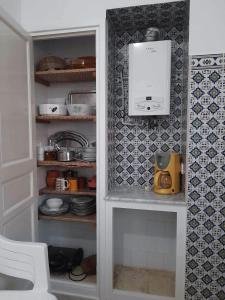 a kitchen pantry with a white cabinet with a appliance at L'espadon de Mahdia Maison avec petit jardin in Mahdia