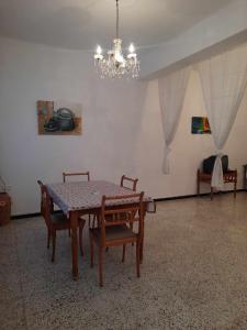 comedor con mesa, sillas y lámpara de araña en L'espadon de Mahdia Maison avec petit jardin en Mahdia