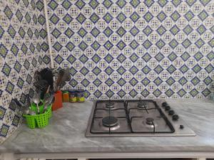 cocina con fogones y pared de azulejos en L'espadon de Mahdia Maison avec petit jardin en Mahdia