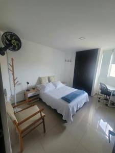 um quarto com uma cama, um banco e uma cadeira em Matilda apt - Feel at home in Barranquilla em Barranquilla