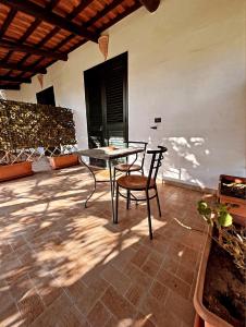 een patio met een tafel en stoelen op een huis bij Case vacanze le Buganville in Ischia