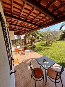 a patio with a table and chairs under a wooden roof at Case vacanze le Buganville in Ischia