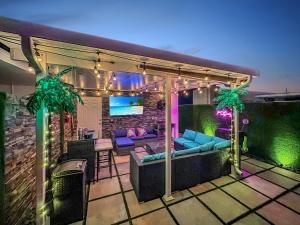 a patio with a couch and a tv on a roof at Vacay Spot experience Luna Sky! 65" TV BAR, BBQ, SHOWER massage jets, music, go to FL Keys in Homestead