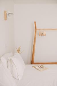 a white bed with a pair of glasses on it at Pure Flor de Esteva in Vila do Bispo