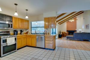 a kitchen with wooden cabinets and a living room at Fort Myers Home, Lanai and Private, Heated Pool in Fort Myers