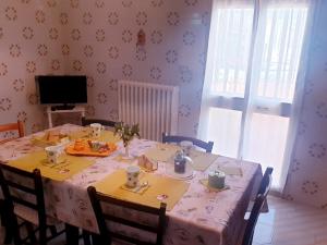 uma mesa de jantar com uma toalha de mesa branca e cadeiras em Appartamento Italia, Centro Città em Gallipoli
