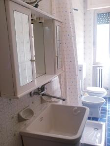 uma casa de banho branca com um lavatório e um WC em Appartamento Italia, Centro Città em Gallipoli