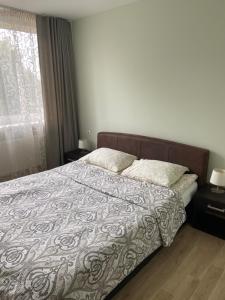 a bedroom with a large bed with a comforter at Butų nuoma Šilutėje in Šilutė