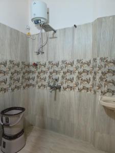 een badkamer met een douchegordijn en een wastafel bij Hotel Ayodhya in Ujjain