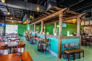 un restaurante con paredes verdes, mesas de madera y sillas en Golf Course 45B, en Destin